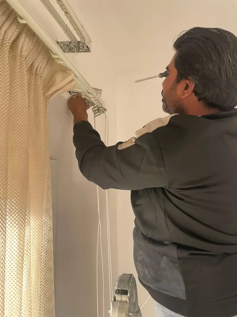 Handyman drilling for a precise curtain railing installation